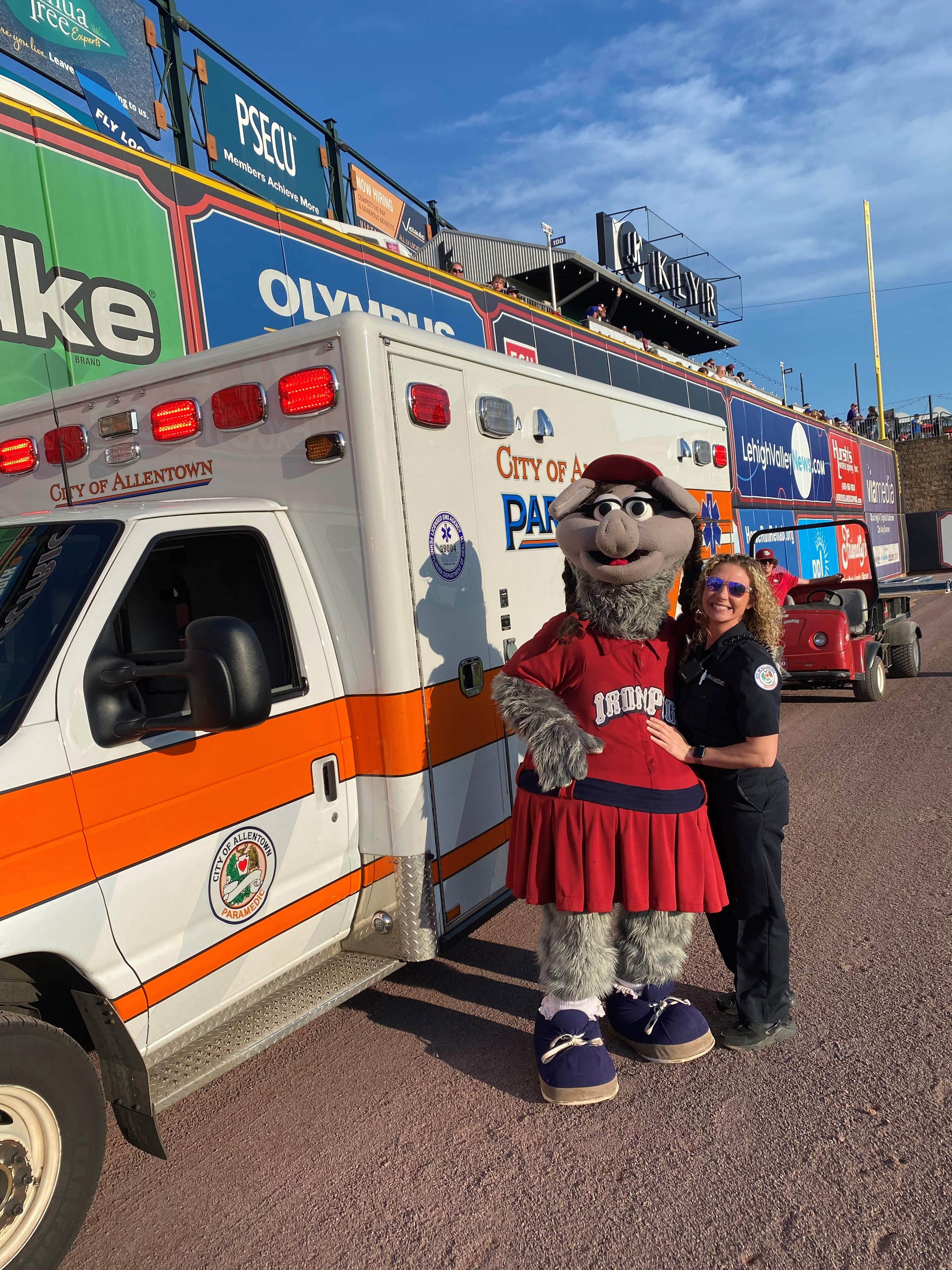 Iron Pigs mascot with a paramedic next to an ambulance.